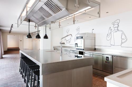 a large kitchen with stainless steel counter tops and appliances at B&B De Vrijboom in Kruisem