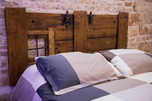 a bed with a wooden headboard and pillows at SINFONIE PUGLIESI LUXURY ROOM in Turi