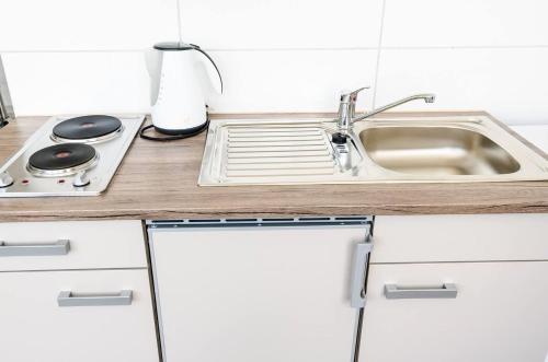 a kitchen counter with a sink and a stove at nJoy! EXPO Studio & Zentral - Stuttgart Flughafen & Messe - perfekt für Work & Travel in Filderstadt
