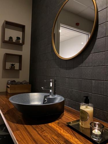 a bathroom with a black sink and a mirror at LA Hotel in Lidingö