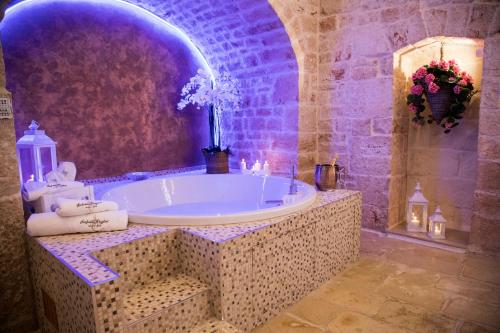 łazienka z dużą wanną, świecami i kwiatami w obiekcie SINFONIE PUGLIESI LUXURY ROOM w mieście Turi