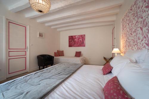 a bedroom with a large white bed and a chair at Le Clos de La Rousselière B and B in Francueil