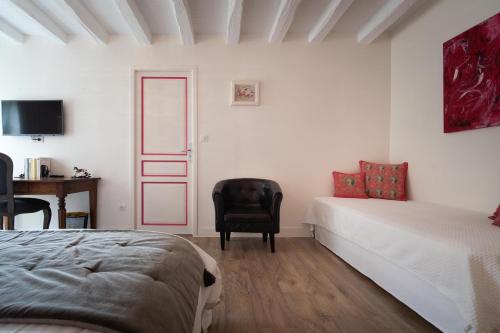 une chambre avec un lit, une chaise et un bureau dans l'établissement Le Clos de La Rousselière B and B, à Francueil