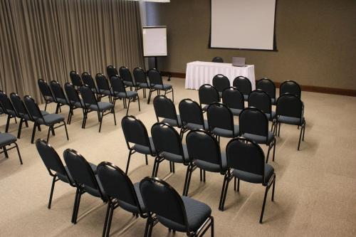 a group of chairs in a room with a white table at Hotel Rainha do Brasil in Aparecida