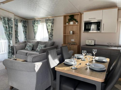 a kitchen and living room with a table and a couch at Yorkshire Lodge with Hot Tub in York