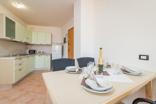 a kitchen and dining room with a table and chairs at Residence Kamenjak in Premantura