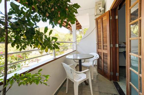 a small table and chairs on the balcony of a house at GH Bizkaia in Florianópolis