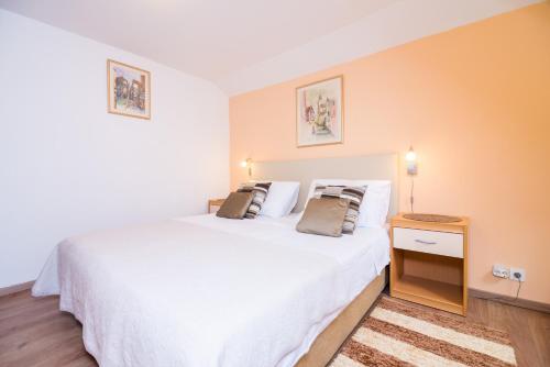 Apartman Neve في دوبروفنيك: غرفة نوم بسرير ابيض كبير مع وسادتين