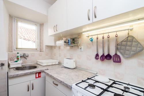 Apartman Neve في دوبروفنيك: مطبخ مع موقد ومغسلة