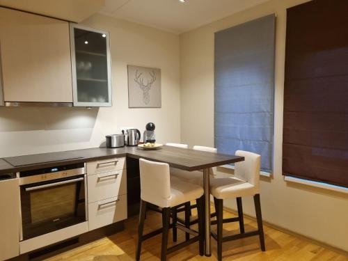 a kitchen with a wooden table and white chairs at R63 Apartment with Terrace in Tartu