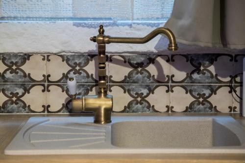 a kitchen sink with a brass water faucet at SINFONIE PUGLIESI LUXURY ROOM in Turi