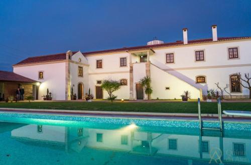 Alpiarça的住宿－Quinta da Atela，一座房子前面设有游泳池