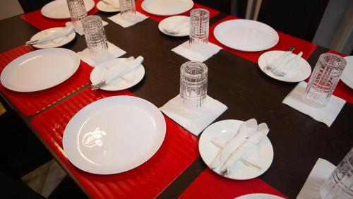 a red table with white plates and napkins on it at Veke Executive Lodge & Event Center in Cape Coast
