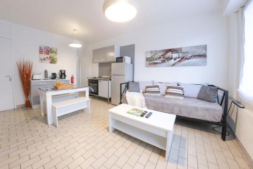 un salon avec un canapé et une table dans l'établissement Les Chevalets II classé 2 étoiles, à Lens