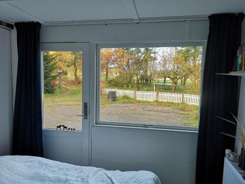 a bedroom with a window looking out at a yard at Keramikhuset 2 komma 0, smuk natur og hjemlig hygge in Horsens