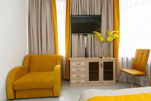 a bedroom with a tv and a chair and a dresser at Hotel Element in Moscow