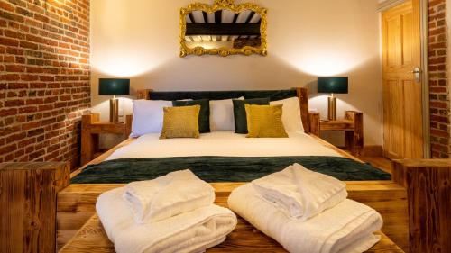 a bedroom with a bed with two pillows on it at The Farmhouse at Fincham in Fincham