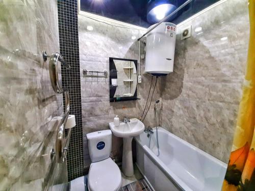 een badkamer met een toilet, een wastafel en een bad bij Уютная квартира класса ЛЮКС в городе Тараз in Taraz