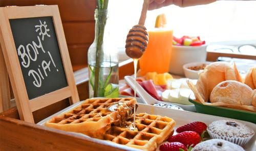 uma mesa coberta com waffles e frutas e uma placa em Pestana São Paulo em São Paulo