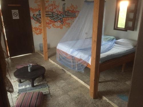 a bedroom with two bunk beds and a table at Deep south Eco-lodge in Marsa Alam City