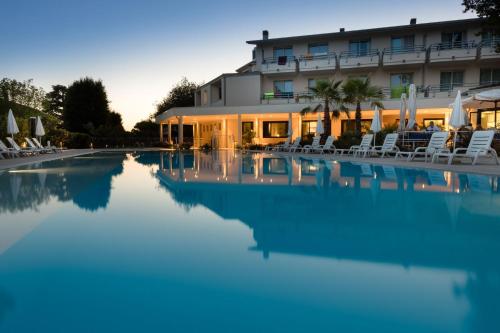 a hotel swimming pool with chairs and a building at Hotel Du Parc in Sirmione