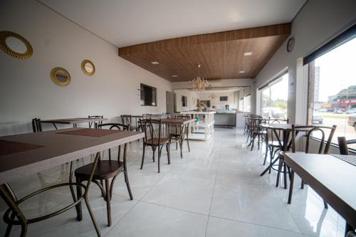 - un restaurant avec des tables et des chaises dans une salle dans l'établissement Hotel Monte Carlo, à Dourados