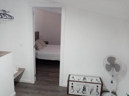 a room with a stove and a bedroom with a bed at EL MIRADOR DE LA TORRE in Constantina
