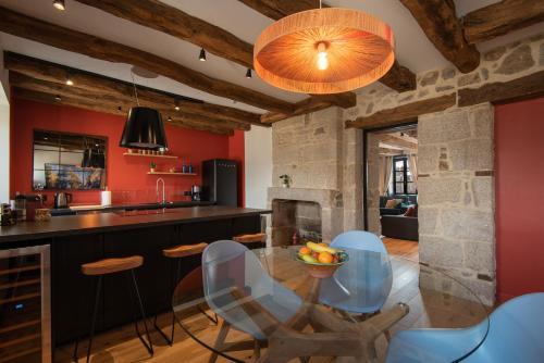 une cuisine aux murs rouges avec une table et des chaises en verre dans l'établissement Luxury two-bedroom apartment, à Dinan