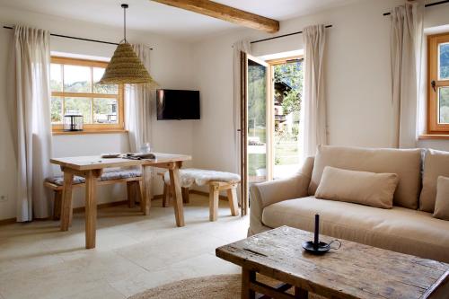 a living room with a couch and a table at Der Schmiedhof in Bayrischzell