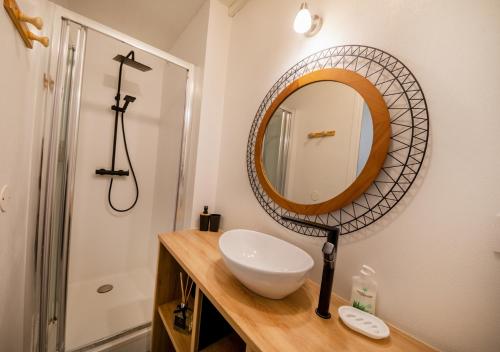 La salle de bains est pourvue d'un lavabo et d'un miroir sur un comptoir. dans l'établissement Chic et Lumineux PROCHE Gare et Parking HYPERCENTRE Agen, à Agen