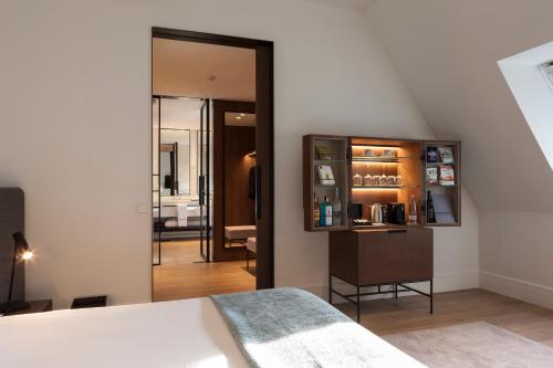 a bedroom with a bed and a large mirror at Kozmo Hotel Suites & Spa - The Leading Hotels of the World in Budapest