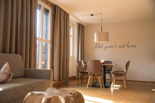 a living room with a couch and a table with chairs at adler alpen apartments in Schruns