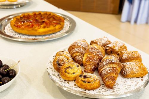 a table with a plate of pastries and a pie at Hotel Du Parc in Sirmione