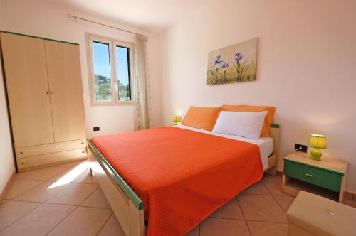 - une chambre avec un lit et une couverture orange dans l'établissement Lorinne Vista Mare Torre Vado, à Torre Vado