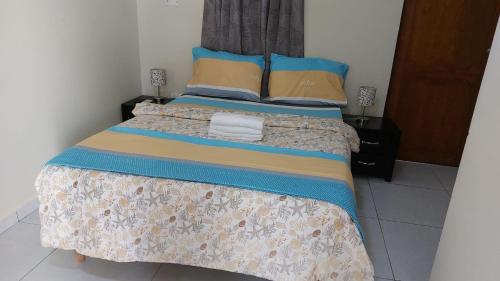 a bedroom with a bed with blue and yellow pillows at Curasita Colour Appartments & Resort - adres kaya Sucre nst 282 in Willemstad