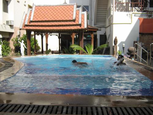 a couple of people swimming in a swimming pool at Prince Hotel Chiang Mai in Chiang Mai