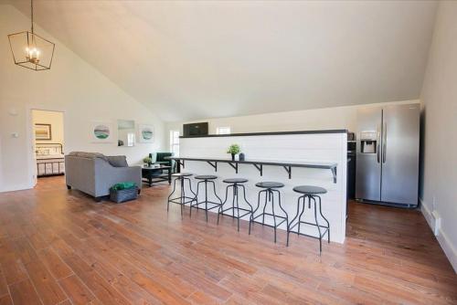 a living room with a kitchen and a bar with stools at Spacious Carriage House with Park Views Near Frankfort Ave & Downtown in Louisville
