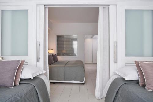 a bedroom with two beds and two windows at Atlantica Aegean Park in Kolimbia