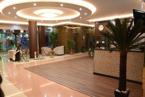 a lobby with a palm tree in a building at Florida Inn Hotel in Najran