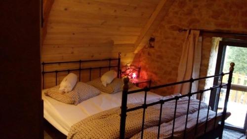 une chambre avec un lit dans une cabane en rondins dans l'établissement chambre namaste, à Montcléra