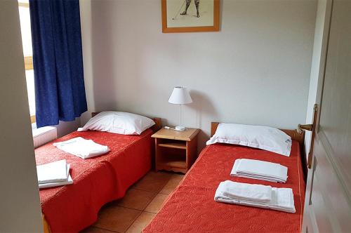 um quarto com duas camas e uma mesa com um candeeiro em Goélia Le Domaine du Golf em Ammerschwihr