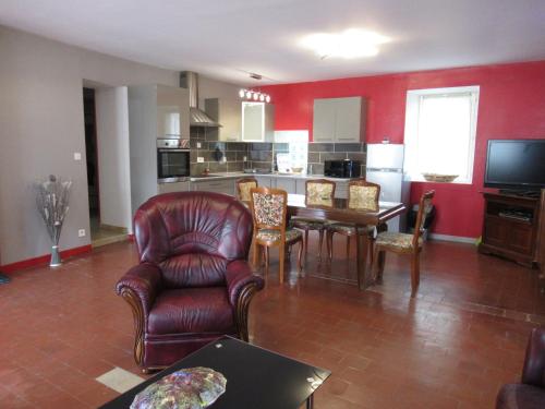 ein Wohnzimmer mit einem Tisch und Stühlen sowie eine Küche in der Unterkunft maison ancienne rénovée tout confort in Narcy