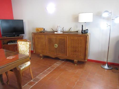 ein Wohnzimmer mit einem TV und einem Tisch mit einer Lampe in der Unterkunft maison ancienne rénovée tout confort in Narcy