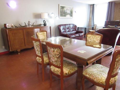 a living room with a wooden table and chairs at maison ancienne rénovée tout confort in Narcy