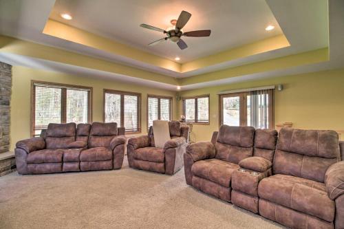 a living room with couches and a ceiling fan at Cabin with Fire Pit and Movie Room, 1 Mi to Lake in Pequot Lakes