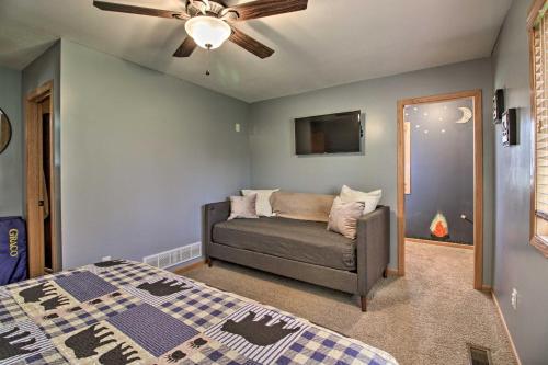 a bedroom with a couch and a ceiling fan at Cabin with Fire Pit and Movie Room, 1 Mi to Lake in Pequot Lakes