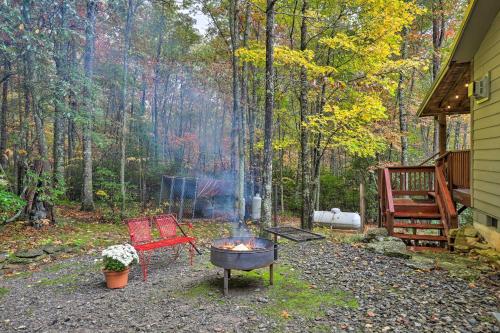 a backyard with a grill and a bench and a fire at Fletcher Cabin Wraparound Deck and Pond Access in Fletcher