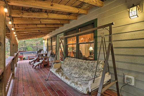 a porch with a swing on a house at Fletcher Cabin Wraparound Deck and Pond Access in Fletcher
