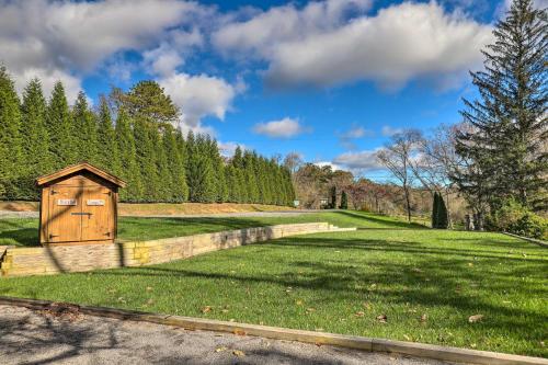 a grassy field with a smallshed in the middle at Fletcher Cabin Wraparound Deck and Pond Access in Fletcher