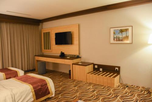 a hotel room with two beds and a desk at Florida Inn Hotel in Najran